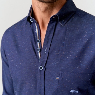 Camisa azul escura com textura e bolso com bordado. 