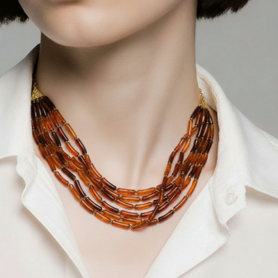Colar de contas âmbar e castanho multicamadas num pescoço com camisa branca