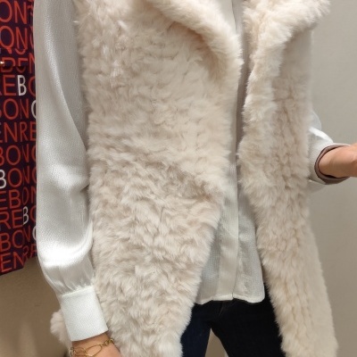 Colete de pelo sintético creme com camisa branca e jeans escuros