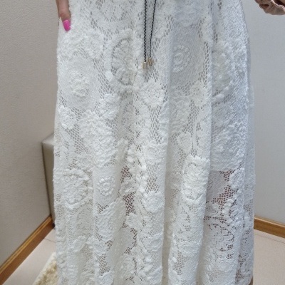 Saia midi branca de renda floral com cordão na cintura e blusa bege.
