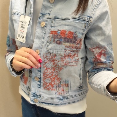 Casaco de ganga azul claro com padrão e etiqueta pendurada