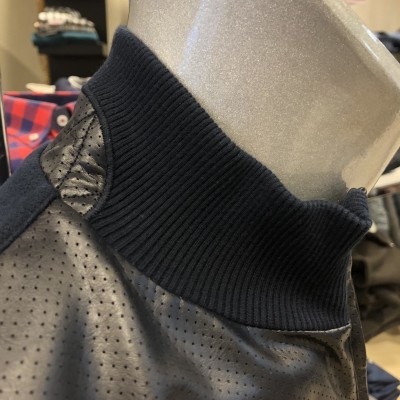 Gola alta preta com peça cinza perfurada em tecido sintético com costura reforçada no ombro