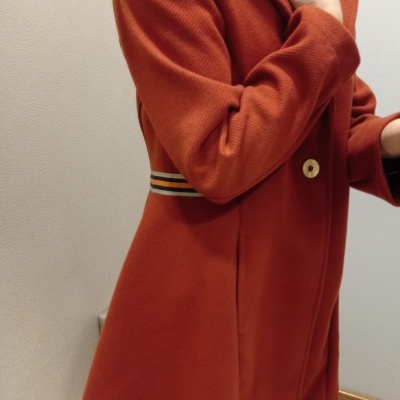 Casaco feminino laranja com cinto listrado e botão bege