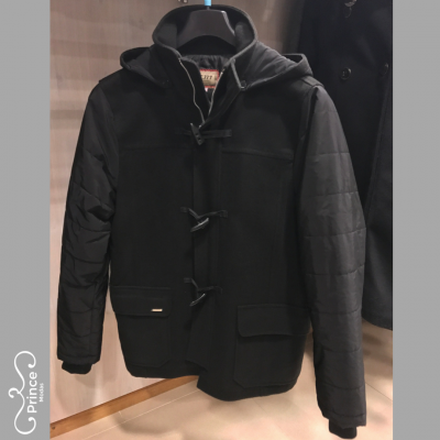 Casaco masculino preto com capuz e fivelas pendurado em cabide