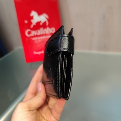 Carteira preta em couro com fecho e caixa vermelha Cavalinho ao fundo