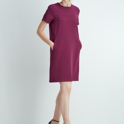 Mulher com vestido bordeaux curto e sapatos pretos de salto alto