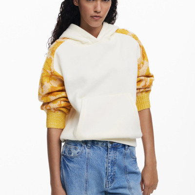 Sweatshirt branca com capuz e mangas amarelas em padrão xadrez com jeans azuis.