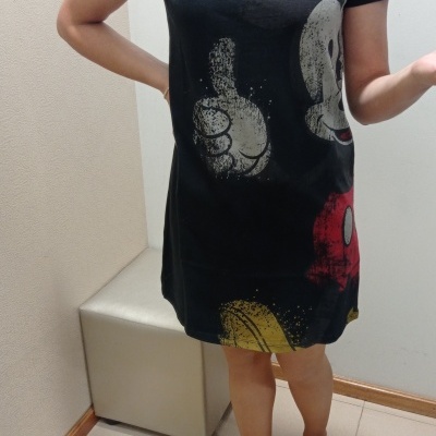 Vestido curto preto com estampa do Mickey Mouse e pessoa a usar