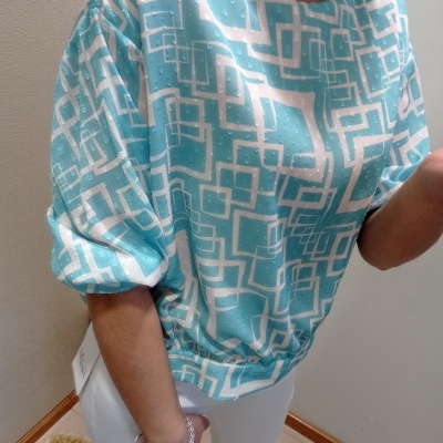 Blusa azul clara com padrão geométrico branco e manga curta franzida
