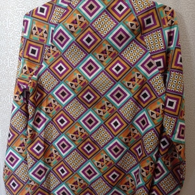 Camisa com padrão geométrico colorido vista pelas costas