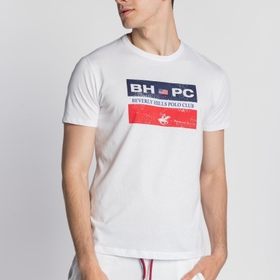 Homem veste t-shirt branca com logotipo 'Beverly Hills Polo Club' e calças brancas com cordão vermelho