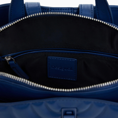 Bolsa azul com fecho aberto e etiqueta Desigual no interior