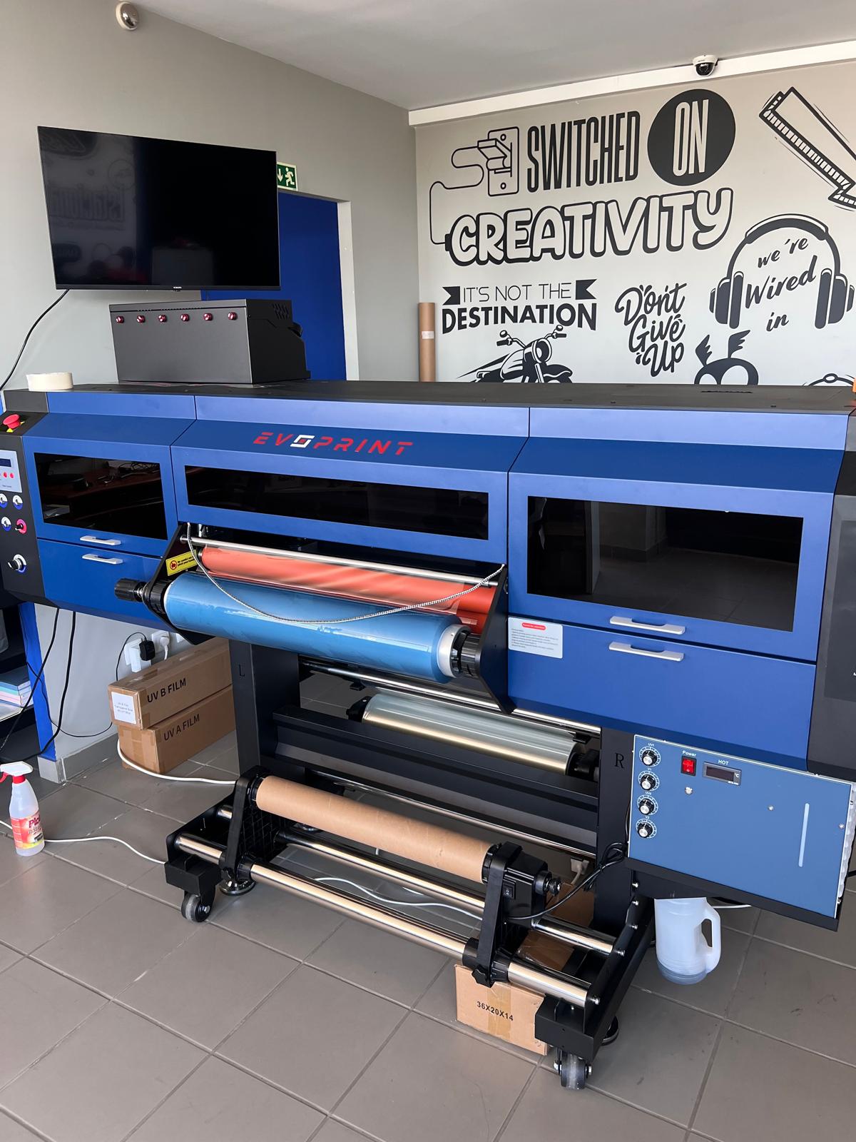 impressora grande formato azul EVOPRINT com rolos de filme e decoração mural
