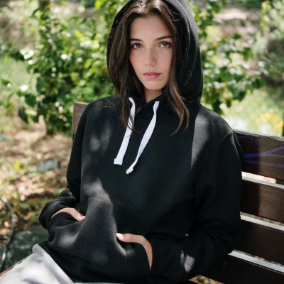 Pessoa com hoodie preto sentado num banco ao ar livre