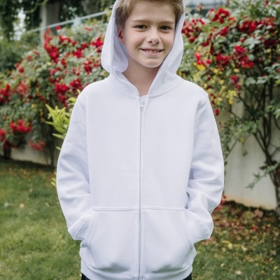 Menino vestido com casaco branco de capuz e fecho de correr em jardim com flores vermelhas