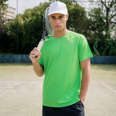 Homem com t-shirt verde e calções pretos numa quadra de ténis a segurar uma raqueta