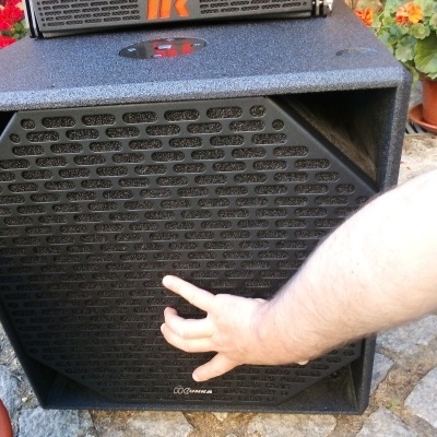 Coluna de som preta com mão segurando a grelha hexagonal