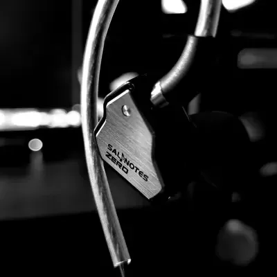 Auscultadores pretos com detalhes metálicos e texto SALMNOTES ZERO