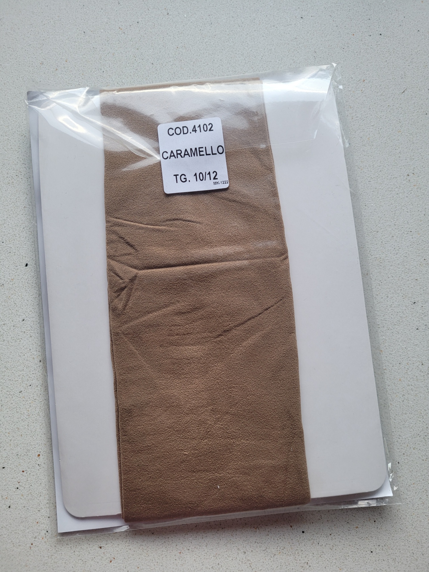 Pacote plástico com tecido castanho caramelo e etiqueta com código e tamanho