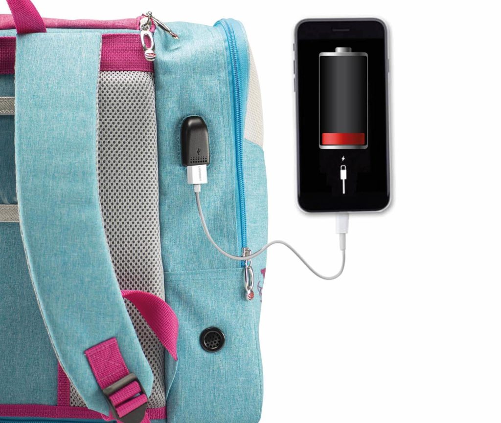 Mochila azul clara com detalhes rosa e uma porta USB integrada a carregar um telemóvel preto.