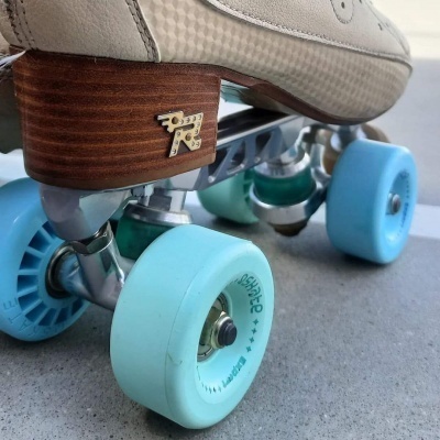 Patim de quatro rodas creme com rodas azuis e base de madeira castanha