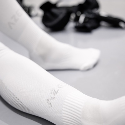 Meias desportivas brancas com texto AZEY em fundo cinza