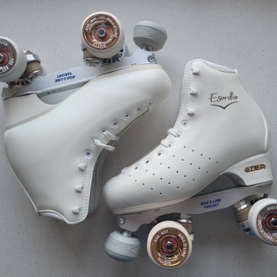 Par de patins de rodas clássicos brancos com rodas castanhas transparentes em fundo claro