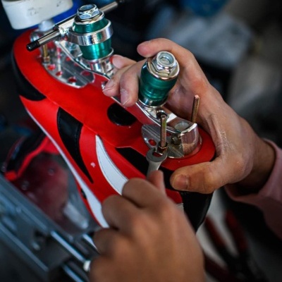 Sapato de patins vermelho com rodas e ferramentas em oficina