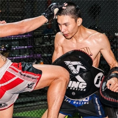 Dois lutadores de muay thai com calções e manoplas TS KING PRO BOXING num ringue de treino