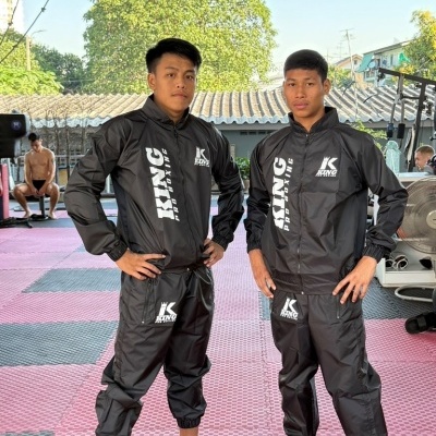 Dois jovens com fato de treino preto KING PRO BOXING e ténis coloridos num espaço de treino