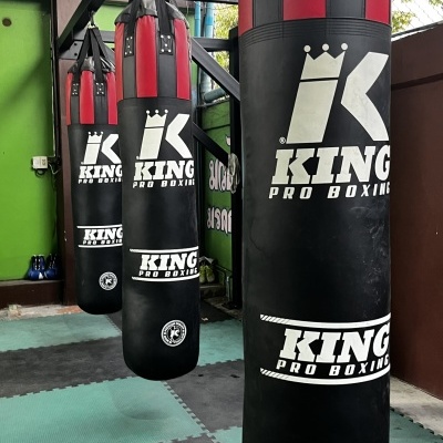Sacos de boxe pretos e vermelhos KING PRO BOXING pendurados num ginásio