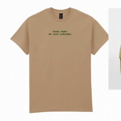 T-shirt bege com frase verde no centro e etiqueta preta na gola
