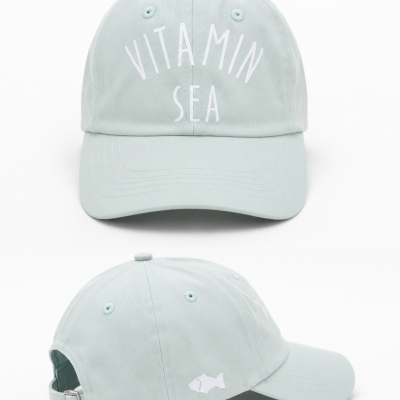 Boné azul claro com texto VITAMIN SEA em branco e estampa de peixe