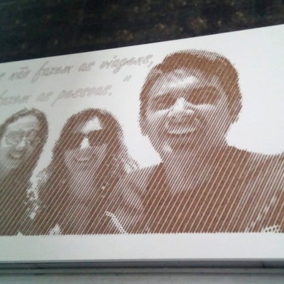 Fotografia sépia de três pessoas sorridentes com texto manuscrito em português no fundo