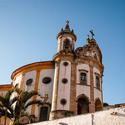 Igreja histórica com paredes brancas e torres com sinos sob céu azul
