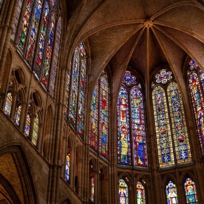 Vitrais coloridos em janelas altas de igreja gótica com arcos de pedra