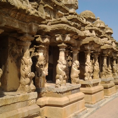 Colunas de pedra esculpidas com figuras detalhadas em estrutura antiga ao ar livre