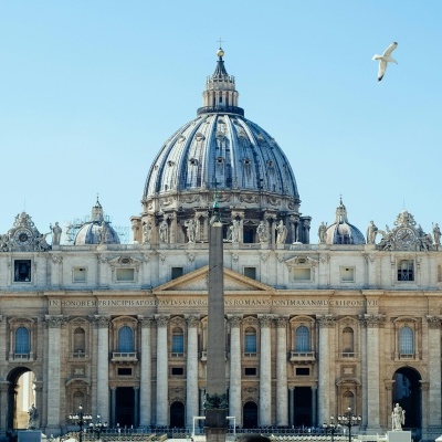 Basílica de São Pedro com cúpula e colunas sob céu azul