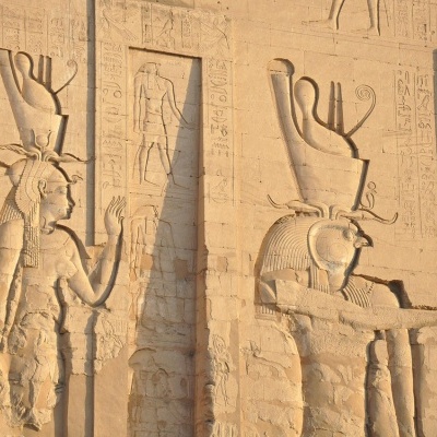 Baixos-relevos egípcios antigos em pedra com figuras humanas e hieróglifos