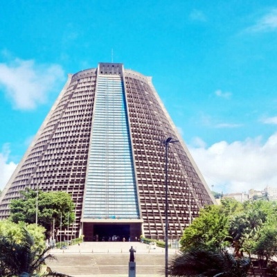 Catedral moderna em forma de cone com torre sineira em céu azul