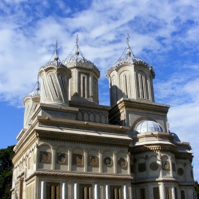 Edifício histórico com cúpulas ornamentadas sob céu azul