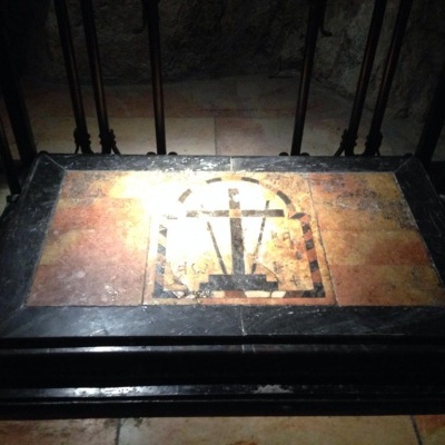 Mesa de madeira escura com tampo de pedra decorativo e proteção metálica ao redor