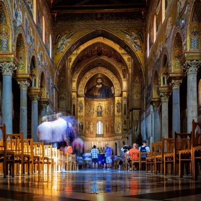 Interior de igreja com pilares, cadeiras e pintura do Cristo