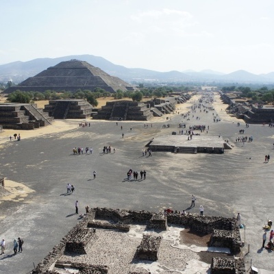 Pirâmides de pedra e visitantes num sítio arqueológico visto de cima