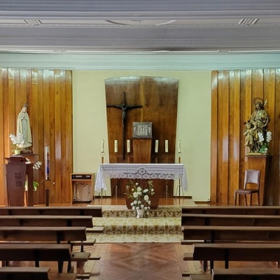 Interior de capela com altar e bancos de madeira