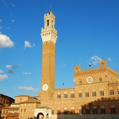 Torre del Mangia e Palácio Público em Siena sob céu azul