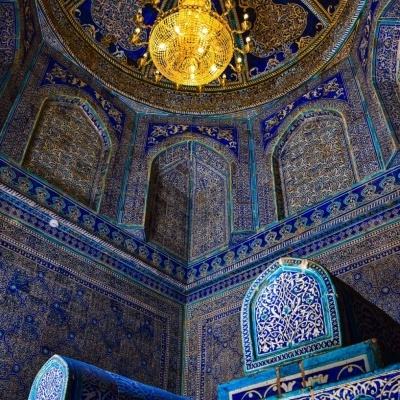 Interior com azulejos azuis e lâmpada dourada suspensa