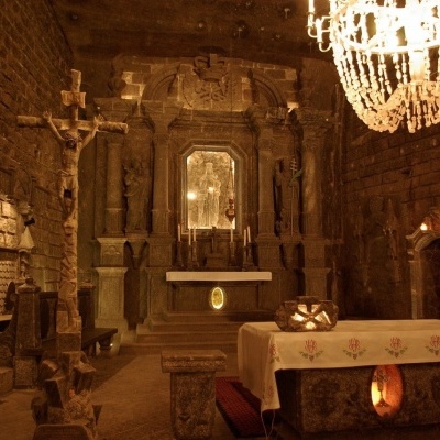 Capela subterrânea de pedra com altar e candelabro