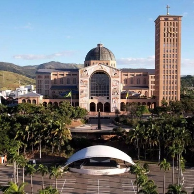 Grande edifício religioso com cúpula e torre em ambiente verde