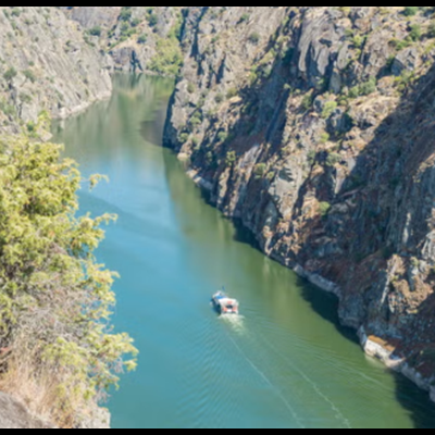 Rio estreito entre falésias rochosas com barco navegando